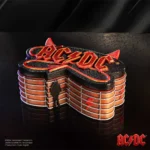 3D metallic red AC/DC logo sculpture with lightning design and architectural rock-inspired details.