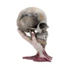 Metallica Skull Sculpture Resin Beige - Skeletal Hand Base A skeletal hand holding a weathered skull engraved with the Metallica logo on a dark background.
