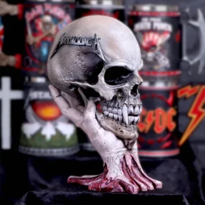 Metallica Skull Sculpture Resin Gray - Skeletal Hand Design A weathered skull held by a skeletal hand with a Metallica logo and metal band mugs behind.