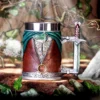 Fantasy Leather Mug Brown Silver Sword Handle - Gold Ring Accent A fantasy-themed mug with a sword handle and gold ring in an enchanted forest setting.