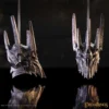 Sauron Helmets Metallic Gray Bronze Spiked Design Reflective Two detailed metallic Sauron helmets with spikes reflecting on a dark glossy surface.