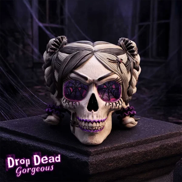 Gothic Skull Sculpture Purple Resin - Spiderweb Eyes and Glow A gothic skull with purple spiderweb eyes, twin buns, and glowing purple teeth on a stone pedestal.