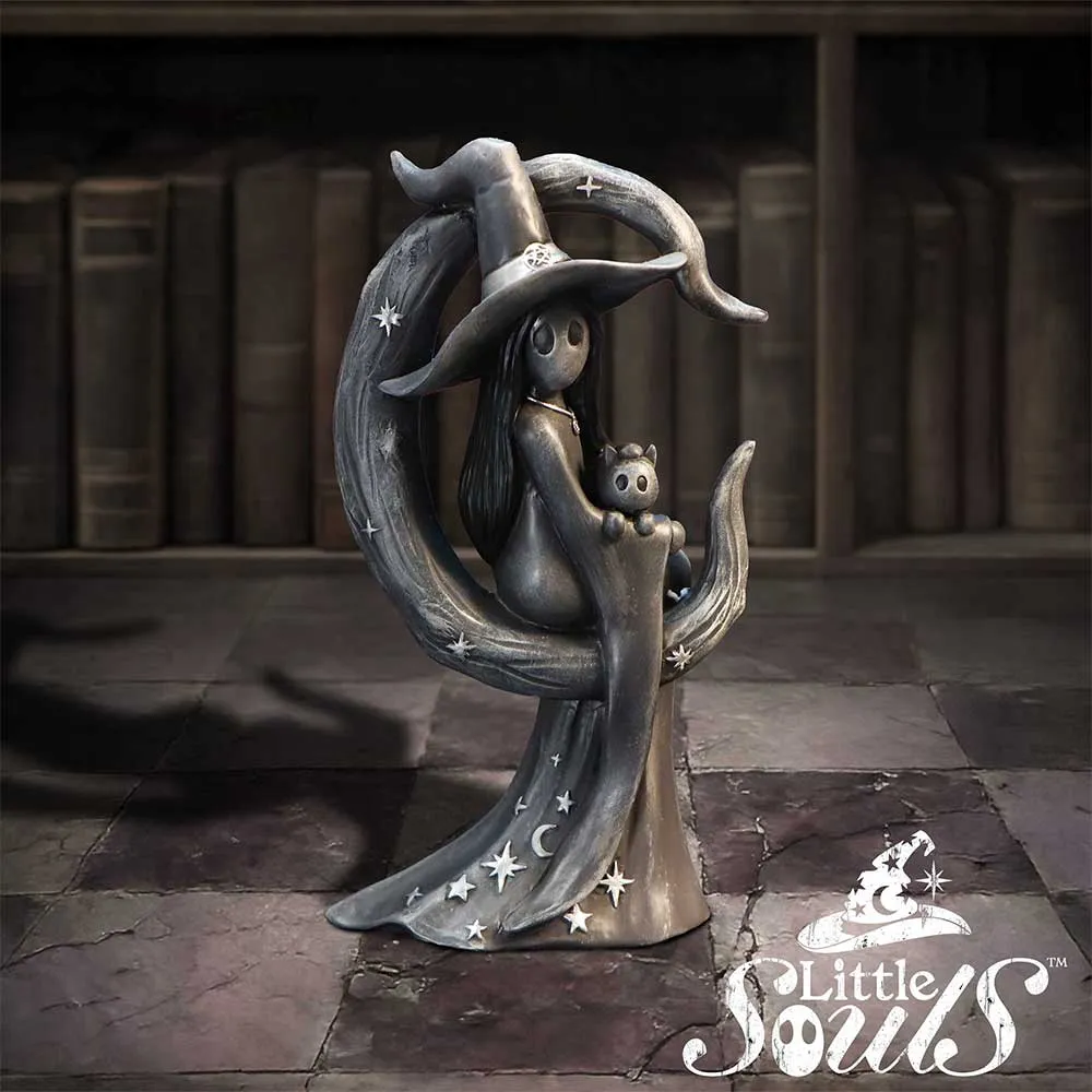A gray witch figurine sitting on a crescent moon holding a small cat sculpture.