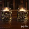 Harry Potter Candle Holders Metal Yellow - Hogwarts Crest Design Collector Shelf - Two ornate Harry Potter candle holders with lit candles on a wooden surface.