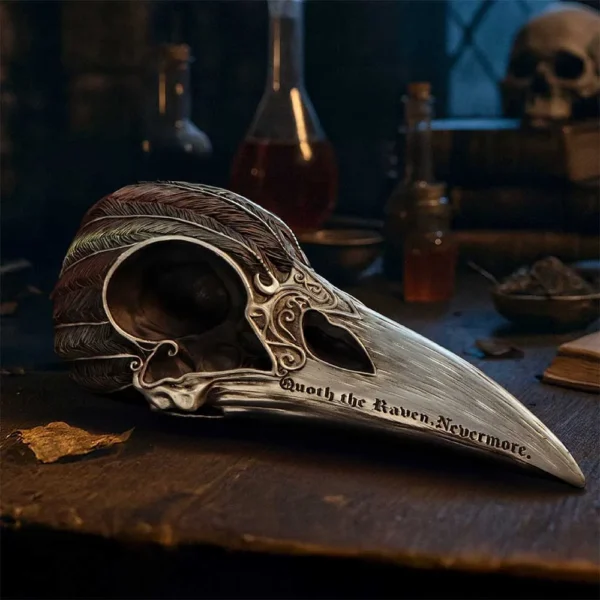Raven Skull Sculpture Metallic Silver - Gothic Etched Design Metal raven skull sculpture on a wooden table in a dimly lit gothic study.