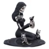 Gothic Skeleton Woman Sculpture Black Resin With Three Cats A gothic black-and-white sculpture of a skeletal woman kneeling with three skeletal cats.