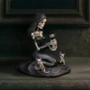 Gothic Skeleton Woman Sculpture Black Resin - Cat Companions A black skeleton woman sculpture gently holding a small skeletal cat surrounded by two others.