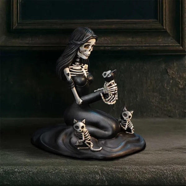 Gothic Skeleton Woman Sculpture Black Resin - Cat Companions A black skeleton woman sculpture gently holding a small skeletal cat surrounded by two others.