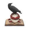 Gothic Raven Skull Sculpture Resin Statue - Black Roses Book A black raven perched on a skull with red roses and an open book beneath.