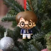 Chibi Harry Potter Ornament Plastic Figure - Blue Sweater Best Gifts For Collectors. Chibi Harry Potter ornament in blue sweater hanging on a festive Christmas tree branch.