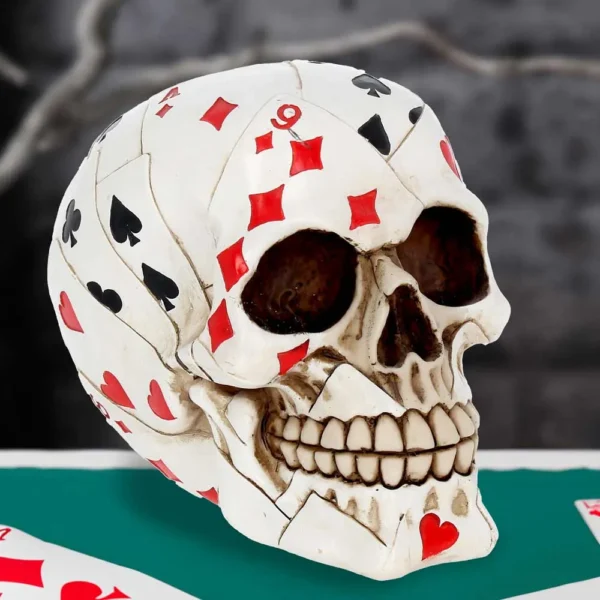 Playing Card Skull Sculpture - Ivory Mosaic on Green Table A human skull sculpture made of playing cards on a green poker table.