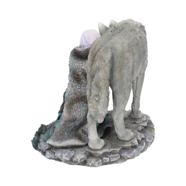 A detailed figurine of a cloaked human seated beside a large gray wolf on a rocky base.