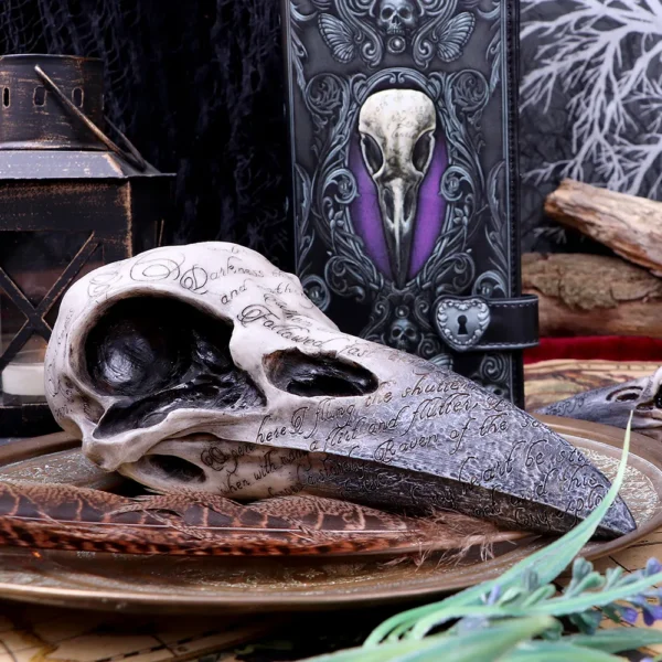 Gothic Raven Skull Sculpture Resin Bone - Bronze Ritual Display A gothic raven skull sculpture on a bronze plate with feathers, lantern, and ornate book.