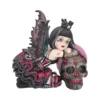 Gothic Fairy Figurine Resin Statue Black Magenta Skull Accent Gothic fairy figurine with dark wings leaning on an ornate magenta-decorated skull.