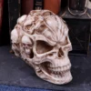 Carved Skull Ornament Resin Sculpture - Ivory With Mini Skulls An intricately carved skull ornament covered with smaller skulls on a dark textured surface.