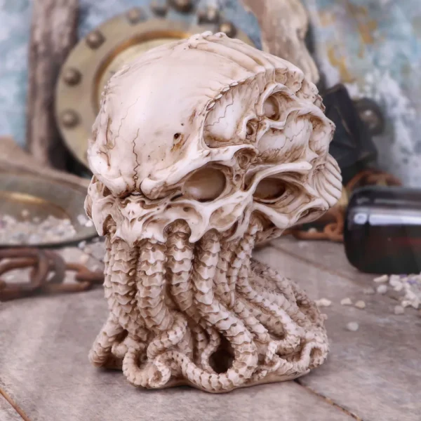 Cthulhu Skull Octopus Sculpture Bone Resin - Nautical Relic A bone-colored skull-octopus sculpture with tentacles displayed among nautical artifacts on a wooden surface.