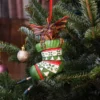 Gremlin Christmas Ornament Stocking Figurine - Green Red Festive Gremlin Christmas ornament peeking from a festive stocking on a decorated tree The-Hidden-Hatch