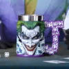Joker 3D Ceramic Mug Purple Handle - “HA” Laugh Design Halloween Gifts A 3D Joker face mug with “HA” handle beside playing cards and a white die.