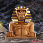 Iron Maiden Eddie Egyptian pharaoh sphinx statue under dark stormy sky with Iron Maiden logo.