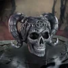 Cosmic Skull Sculpture Dark Gray Resin With Ram Horns Dark gray skull with galaxy eyes, ram horns, and occult symbols on a misty altar background.