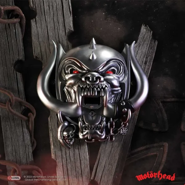 Motörhead Snaggletooth Metallic Sculpture - Red Eyes Chains Metallic Motörhead Snaggletooth sculpture with red eyes and chains on dark wood background The-Hidden-Hatch