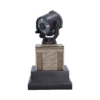 A detailed black and gold Bat-Signal spotlight replica on a decorative pedestal display base.