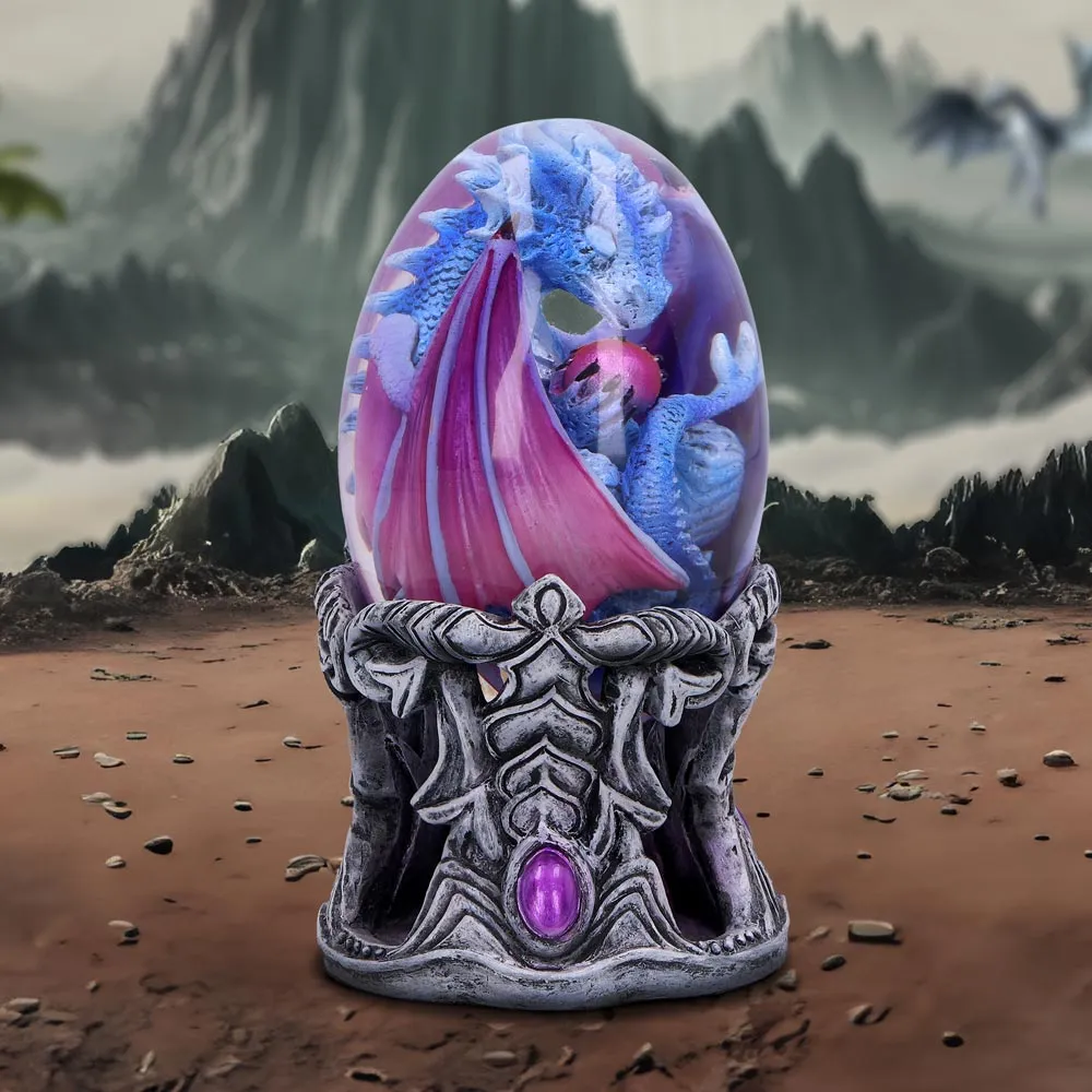 A Guide to Magical Gift Shopping 3 Magical Gifts. A blue dragon inside a transparent egg on an ornate pedestal with a misty mountain background.