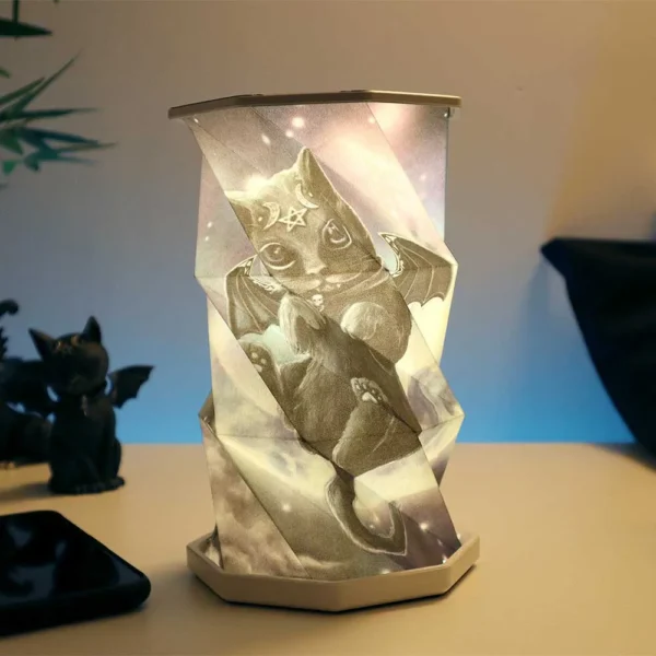Origami Lamp Paper Design White - Mystical Black Cat Wings An origami-style glowing lamp featuring a mystical black cat with bat wings on a desk.