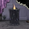Black Wax LED Candle Gothic Decor - Purple Velvet Glow Black gothic LED candle with melting wax and warm flame beside purple velvet and starry backdrop.