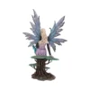 Blonde Fairy Figurine Resin Sculpture - Blue Shimmering Wings A blonde fairy figurine with shimmering wings sitting on a detailed tree base with moss-like texture.