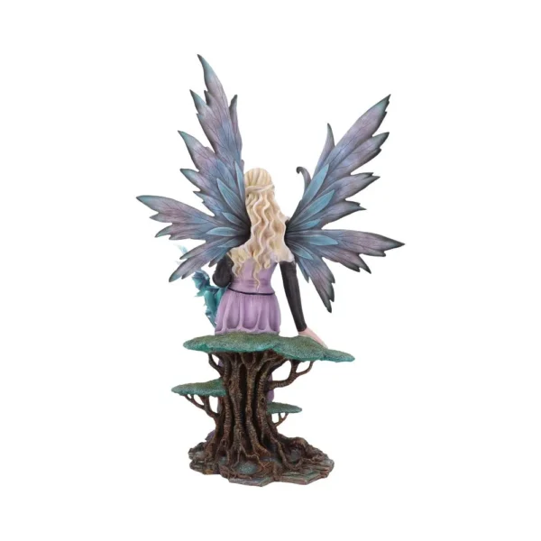 A blonde fairy figurine with shimmering wings sitting on a detailed tree base with moss-like texture.