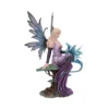 Fairy Figurine Resin Sculpture Lavender Dress With Blue Wings A fairy figurine with blue-purple wings sitting on a tree stump holding a small dragon.