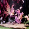 A pink-haired fairy kneeling beside a small purple dragon on a rocky wooden platform.
