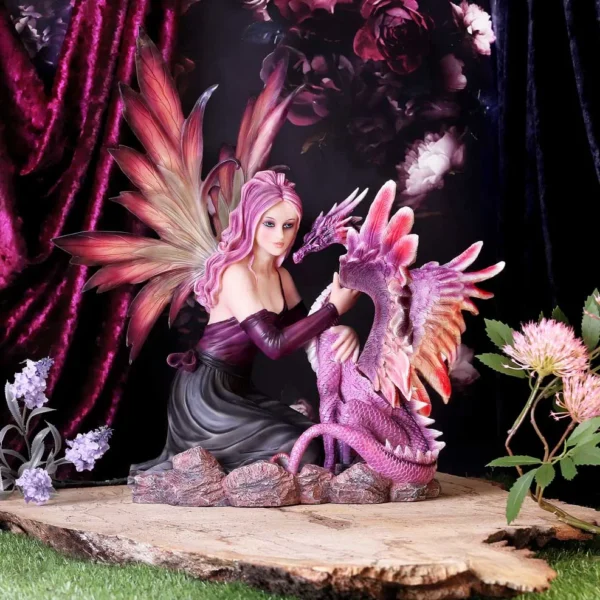A pink-haired fairy kneeling beside a small purple dragon on a rocky wooden platform.
