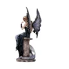 Gothic fairy figurine with dark wings seated on stone beside a coiled lavender dragon.