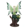 A detailed fairy figurine with green wings and a tiny dragon perched on a tree branch.