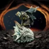 Knight Statue Resin Figure Gold Black - Slaying Petrified Dragon Collector Shelf A kneeling armored knight atop a petrified dragon head in a fiery cavern setting.