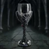 Gothic Goblet Glass Chalice Black With Goat Head And Skulls A gothic black goblet with goat head, wings, red gems, and skull base in dim light.