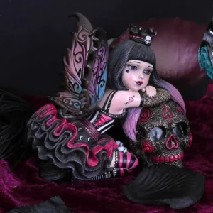 Gothic Fairy Figurine Resin Statue - Purple Wings And Skull Gothic fairy figurine with purple wings holding ornate skull on dark velvet background.