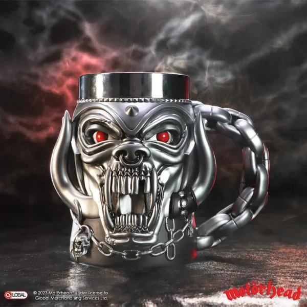 Motörhead Snaggletooth Metal Mug Chrome Finish - Chain Handle Fandom Gifts. Chrome Motörhead Snaggletooth mug with chain handle and smoky red background, official licensed collectible.