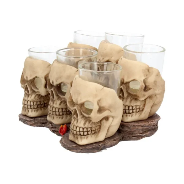 Skull Shot Glass Set Resin Holders Beige - Gothic Bar Decor Six resin skull shot glass holders with clear glass inserts on a dark textured base.