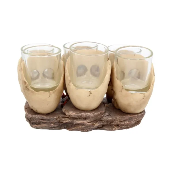 Skull Jaw Shot Glass Set Resin Beige - Gothic Rustic Base Design Four clear shot glasses held in beige skull-jaw shaped holders on a rustic wood-like base.