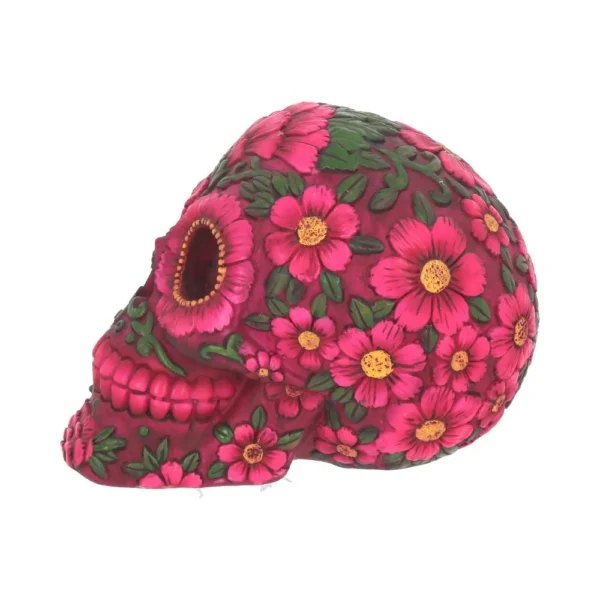 A pink decorative Day of the Dead skull with embossed soap flowers and green leaves.