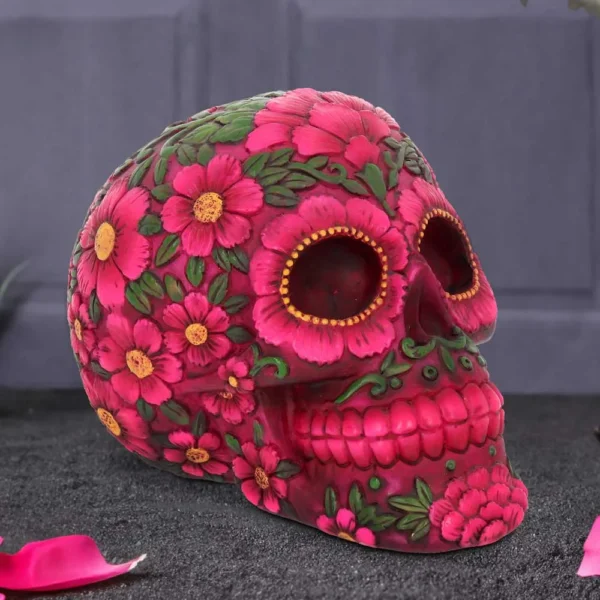 Mexican Calavera Skull Sculpture Pink Floral Design - Handcrafted A colorful floral-decorated Mexican skull sculpture with pink soap flowers and green leaves for Day of the Dead.