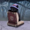 Black Cat Witch Figurine Resin Sculpture - Purple Hat and Spellbook Goth Black cat figurine in witch hat resting on ornate magic book in eerie forest setting The-Hidden-Hatch