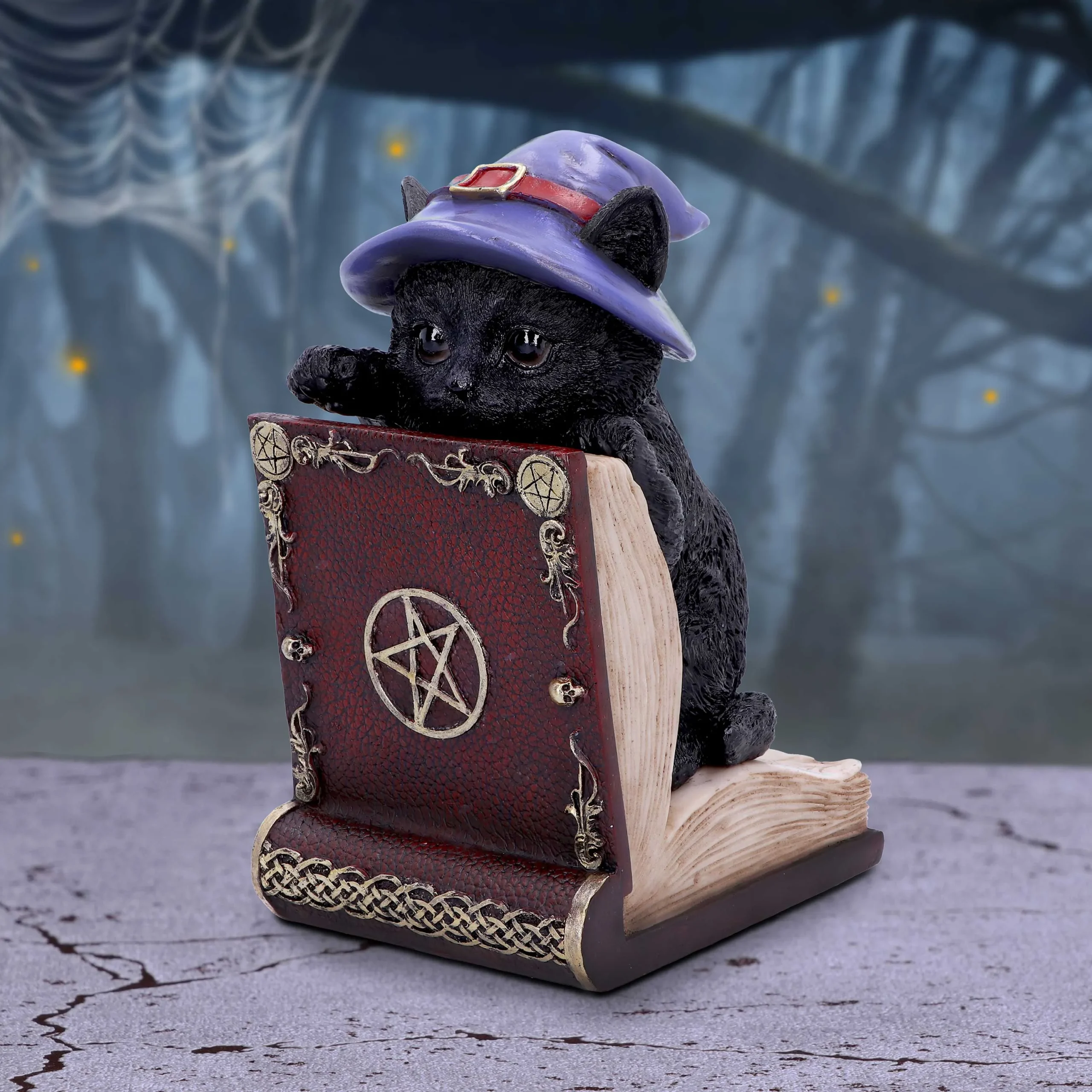 About Us 5 Black cat figurine in witch hat resting on ornate magic book in eerie forest setting The-Hidden-Hatch
