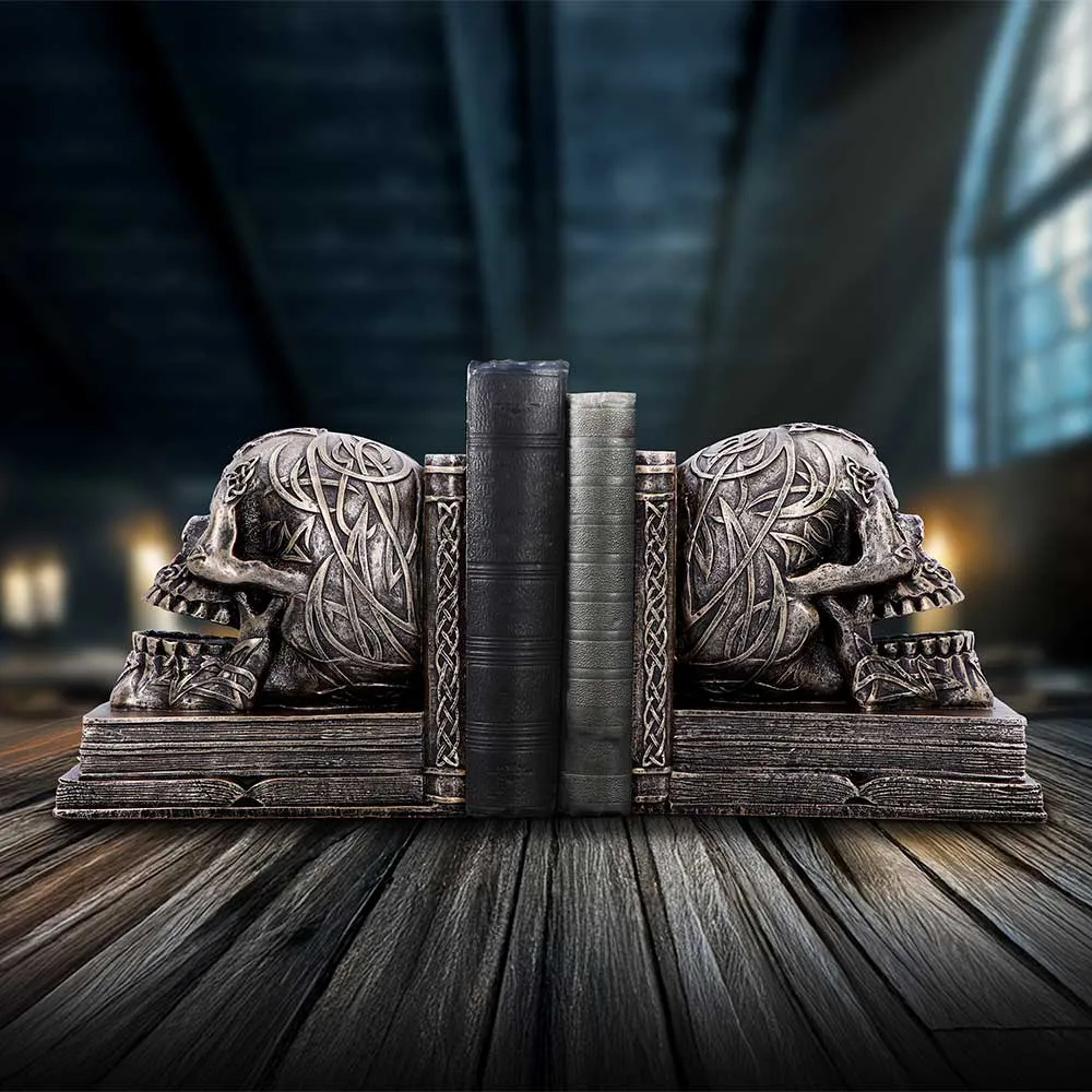 Halloween Decor Trends Worth Trying 4 Halloween Gifts: Ornate Celtic skull bookends holding antique leather books on a wooden surface. The-Hidden-Hatch